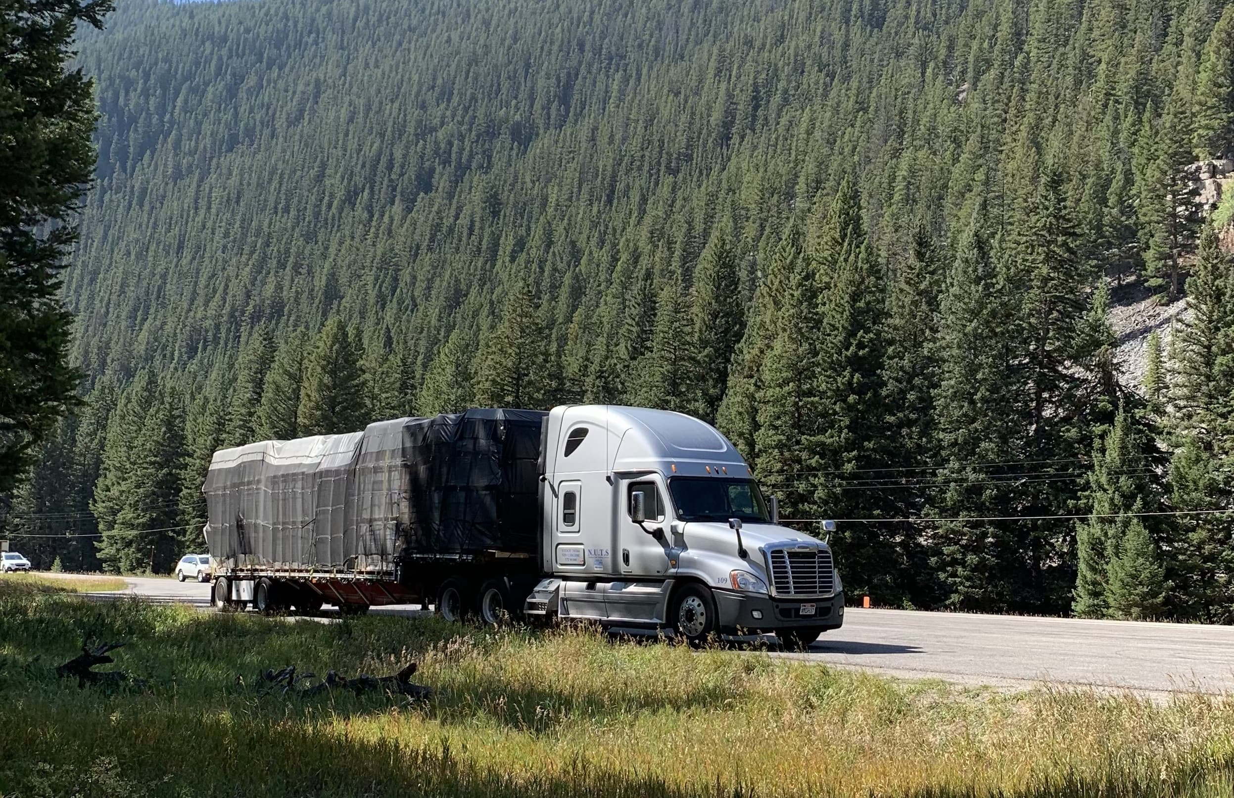 Semi-truck carrying freight along a Western highway.